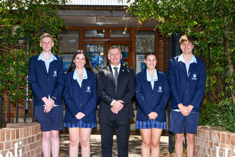 4 student with principal in the middle out front of school