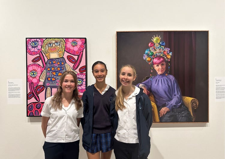Three female year 11 students with paintings