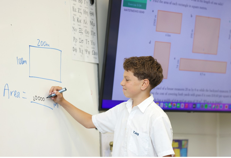 boy writing on whiteboard